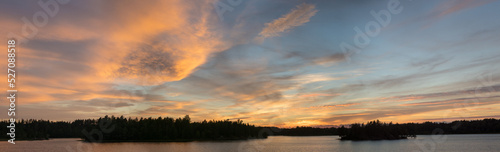 panorama of a dramatic sunset over a forest lake