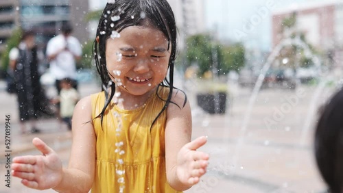 駅前広場の噴水で水浴びして遊んでいる女の子