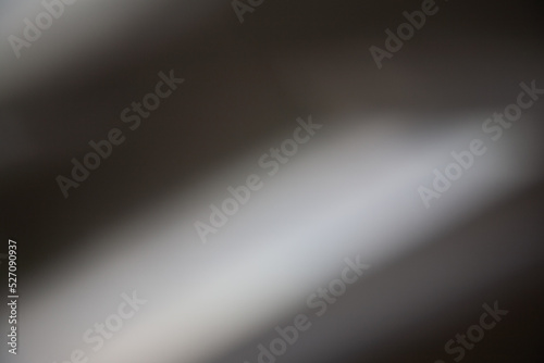 Blur glow background. Light leak. Bokeh optical glare. Defocused brown white color gradient rays on dark abstract copy space texture.