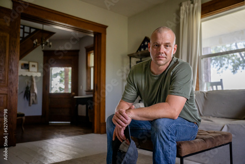 Marine veteran at home with family poses for portrait.