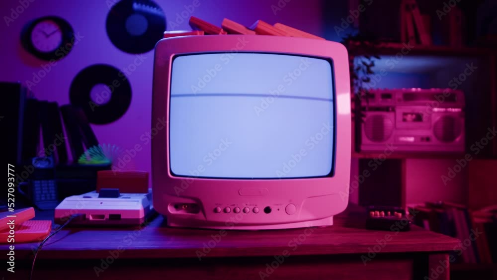 Old television with blue interference screen in retro room. Close-up of vintage tv and cartridges for playstation. Antique video game, nostalgia. 