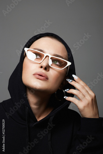 stylish bald girl in Hood. fashionable glasses