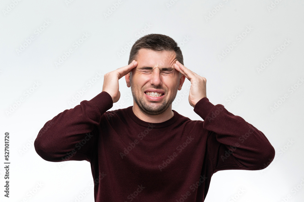Handsome man wearing casual sweater feeling tired and headache, Stress and headache concept. Handsome man wearing casual sweater feeling tired and headache, Stress and headache concept.