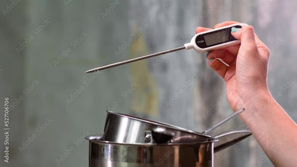 The temperature of the boiling syrup in the pan is measured with an
