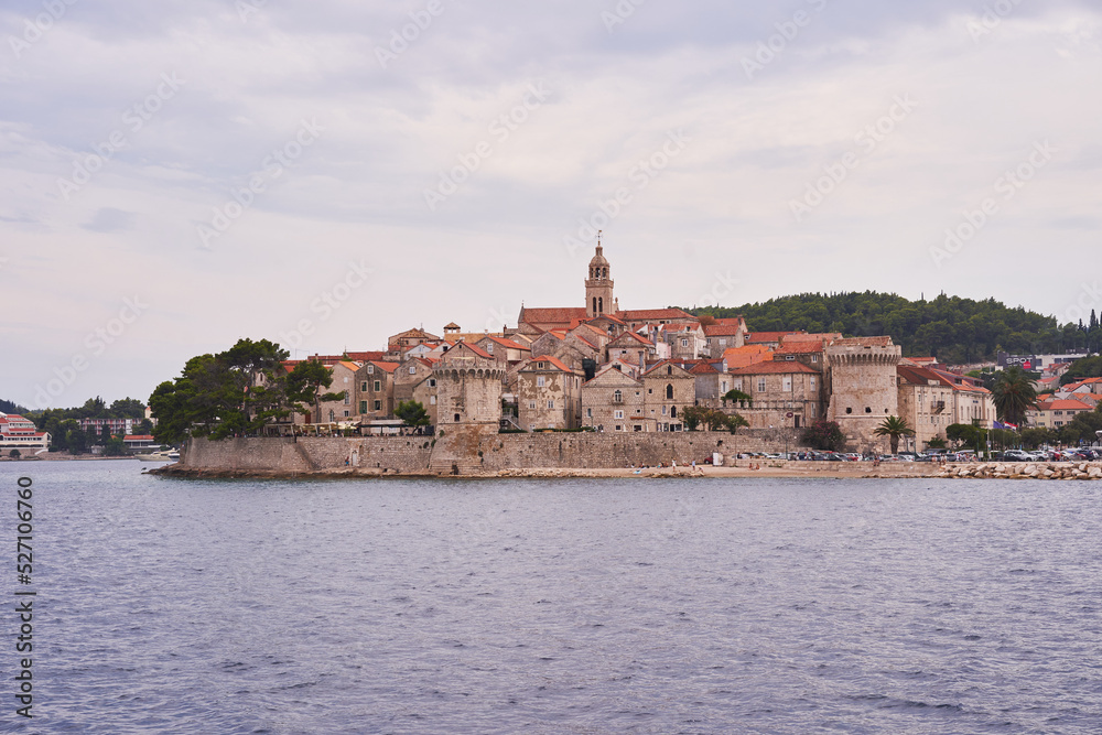 Landscape picture of old town Korcula taken fom the adriatic sea during the cloudy summer day. Pitoresque historic old city on the Korcula island in south dalmatian region of Croatia.
