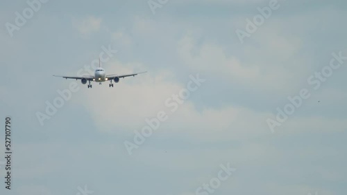 Front view of apassenger aircraft descending for landing. Jet plane approach. Airliner in the cloudy sky. Tourism and travel concept photo