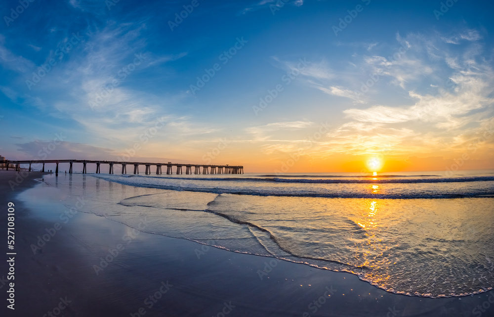 Fototapeta premium Sunrise over the Atlantic Ocean and the Jacksonville Baech pier in Jacksonville Beach Florida USA