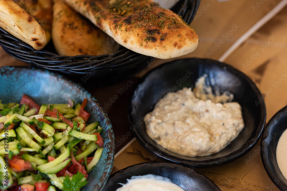 Israel and Lebanon cuisine served in restaurant. Middle eastern or Arabic Oriental restaurant. Several appetizer dishes and spreads for bread  and salad. 