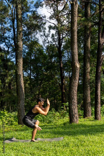 young man, doing yoga or reiki, in the forest very green vegetation, in mexico, guadalajara, bosque colomos, hispanic,