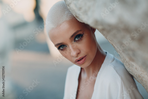 Portrait of young millenial european short haired woman. Beautiful happy blonde girl outdoor. Summer fashion female clothing. photo