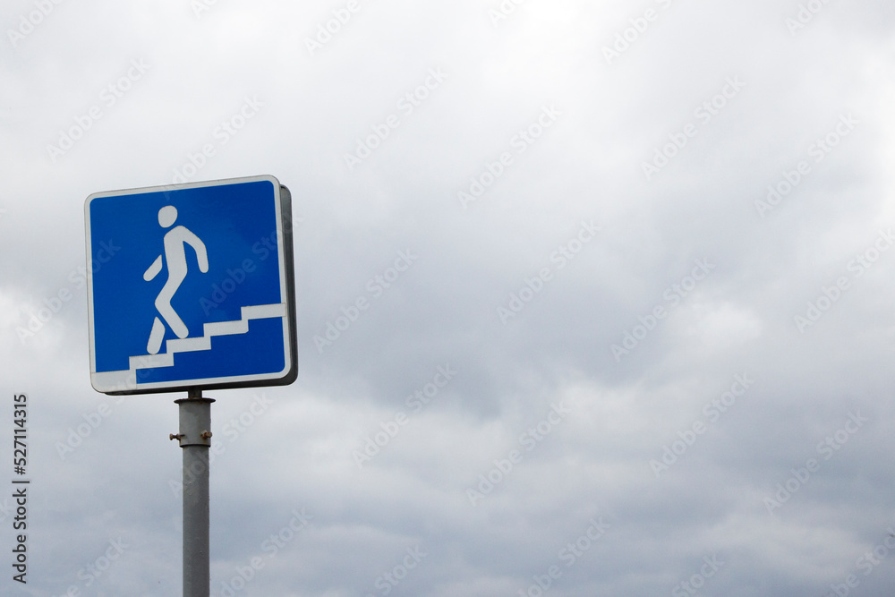 Warning blue road sign of an underground passage at the street with the sky in the background on the daytime. Warning blue road sign of an underground passage at the street with the sky in the background on the daytime.
