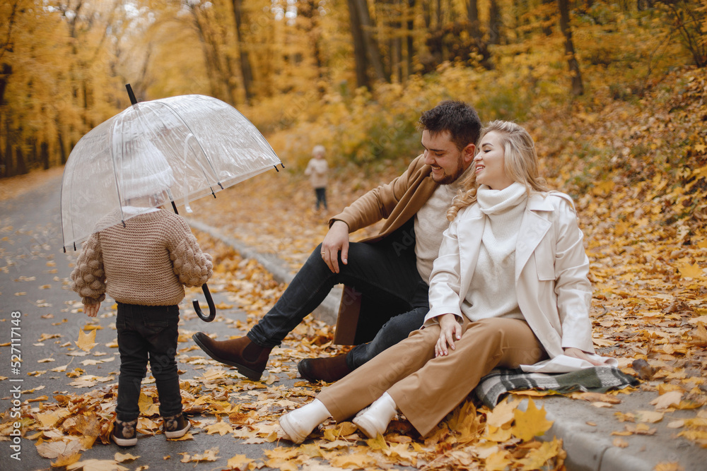 Beautiful young family on a walk in autumn forest