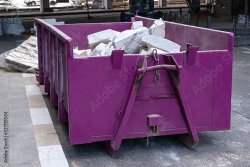 Purple metal dumpsters container full of construction garbage, house renovation. photo