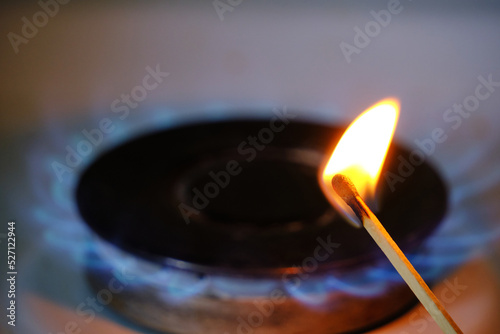 Burning match against background blue flame burning burner.