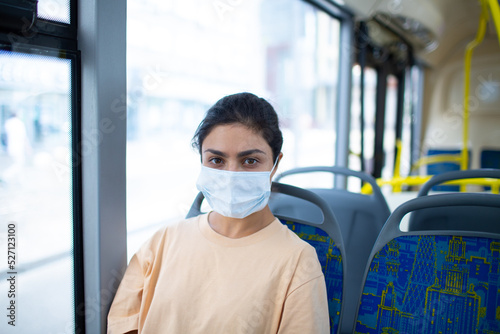 Indian Woman ride in public transport bus or tram in medical face mask