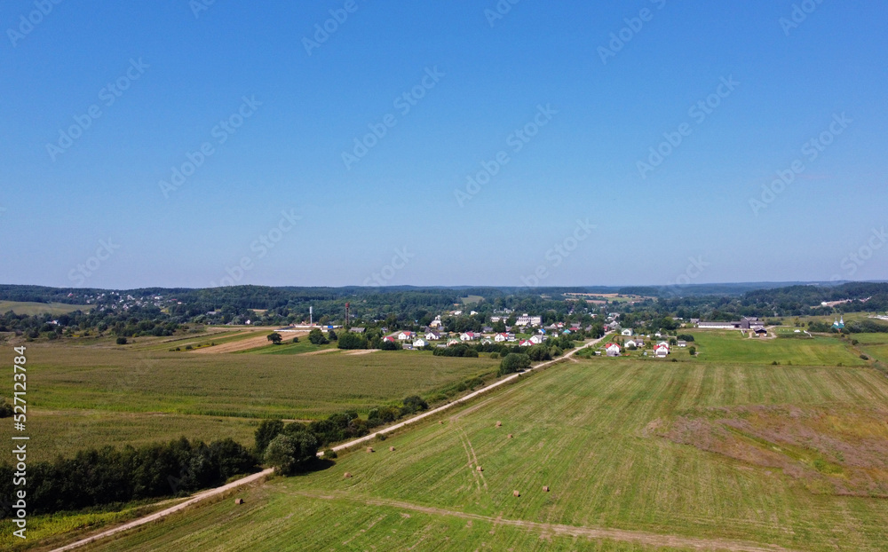 Aerial view of agro fields with harvesting and haystacks