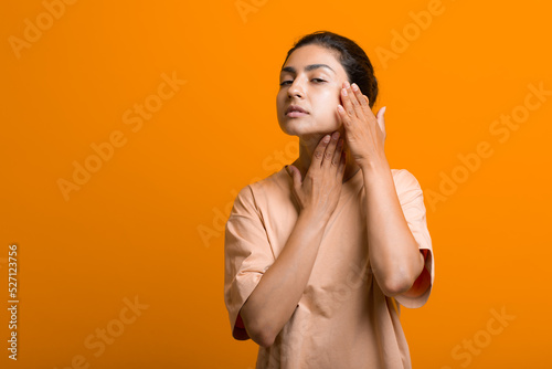 Close up portrait of young indian american woman doing facebuilding yoga face gymnastics yoga self massage photo