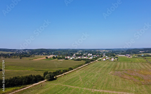 Aerial view of agro fields with harvesting and haystacks