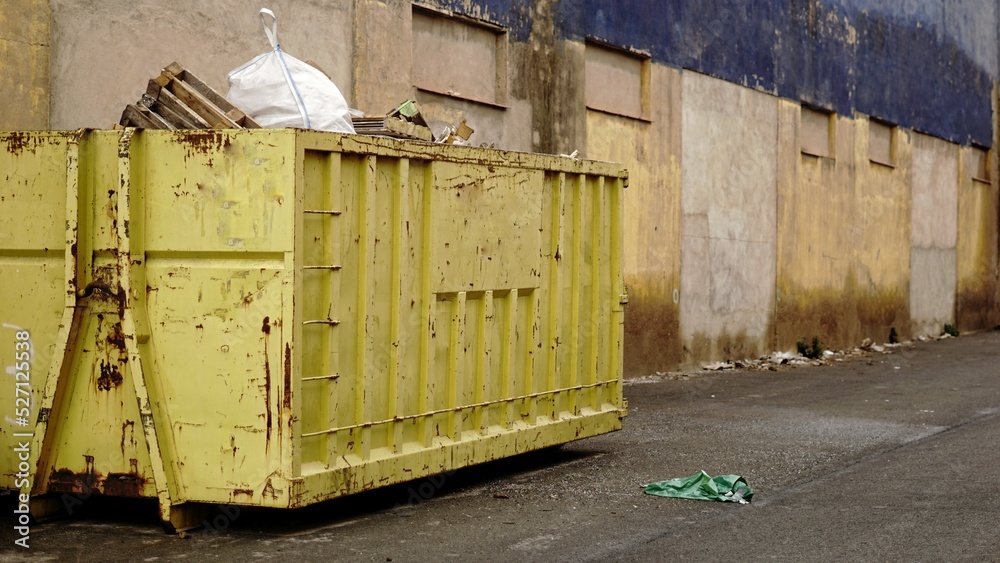 full yellow industrial debris container side view