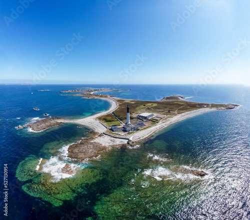 Great lighthouse of the Island of Sein in Brittany, France, in the Atlantic Ocean - Small flat isolated island with a black and white, tall and round lighthouse photo