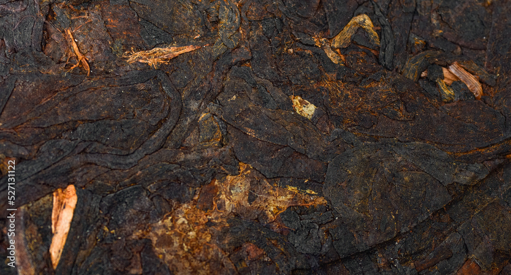 Pressed Chinese fermented Pu-erh tea. Macro close up. Aromatic black puer tea. Healthy drink. Texture. Pressed Chinese fermented Pu-erh tea. Macro close up. Aromatic black puer tea. Healthy drink. Texture.