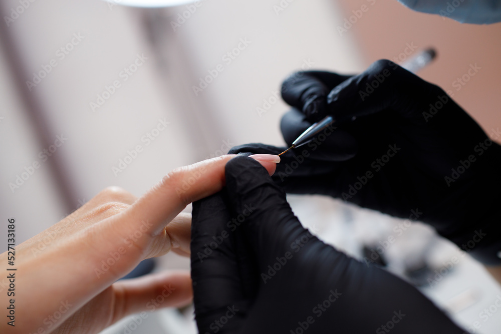 Manicure process female hands finger nails polish. Beautician in gloves