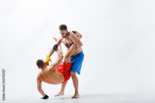 Two men boxers fighting muay thai boxing white background. © primipil