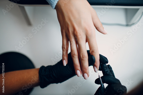 Manicure process female hands finger nails lacquer applying nail polish.