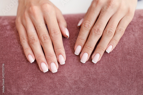 Female hand fingers nails with manicure after nail salon procedure.