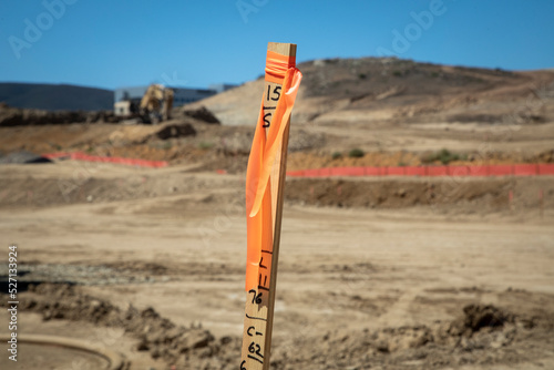 Fotografija Construction grading stake with construction equipment in background