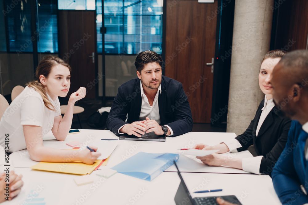 Businessman and businesswoman team at office meeting. Business people group conference discussion sit at table with boss man and woman Businessman and businesswoman team at office meeting. Business people group conference discussion sit at table with boss man and woman