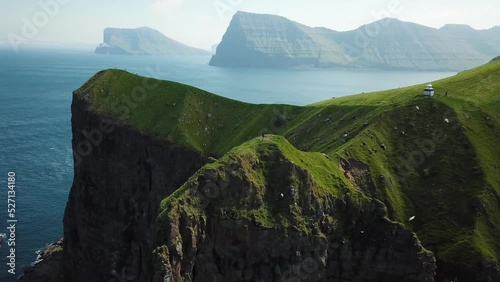 Aerial view of Kalsoy island, Faroe Islands. Amazing Faroese nature, green hills and beautiful rocky cliffs and mountains. Kallur lighthouse. Sunny day in summer. Movie Island in Faroe. 4k footage