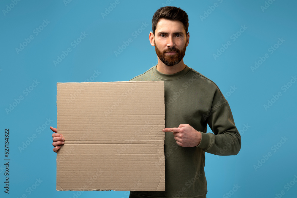 Caucasian cheerful man holding empty carton placard and smiling Caucasian cheerful man holding empty carton placard and smiling