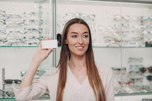 Young Adult Woman hold box package without inscriptions empty space at optician.