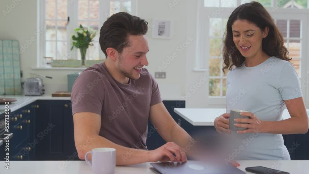 Excited Pregnant Transgender Couple At Home In Kitchen Together With Man Touching Woman's Stomach Excited Pregnant Transgender Couple At Home In Kitchen Together With Man Touching Woman's Stomach