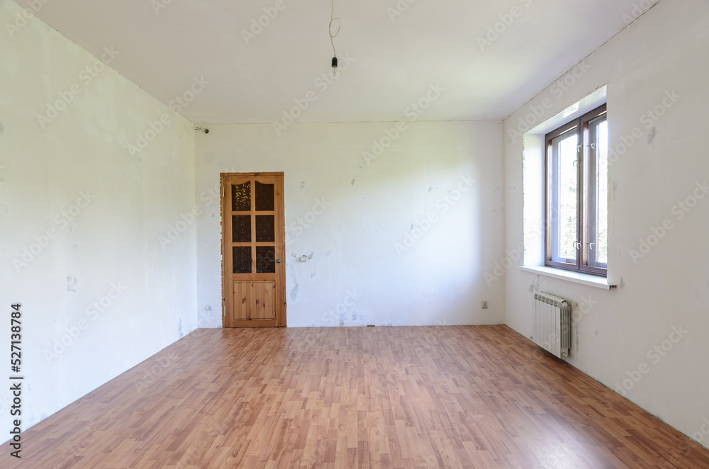 Fragment of a room with a fine finish, view of the front door, there is one window in the room Fragment of a room with a fine finish, view of the front door, there is one window in the room
