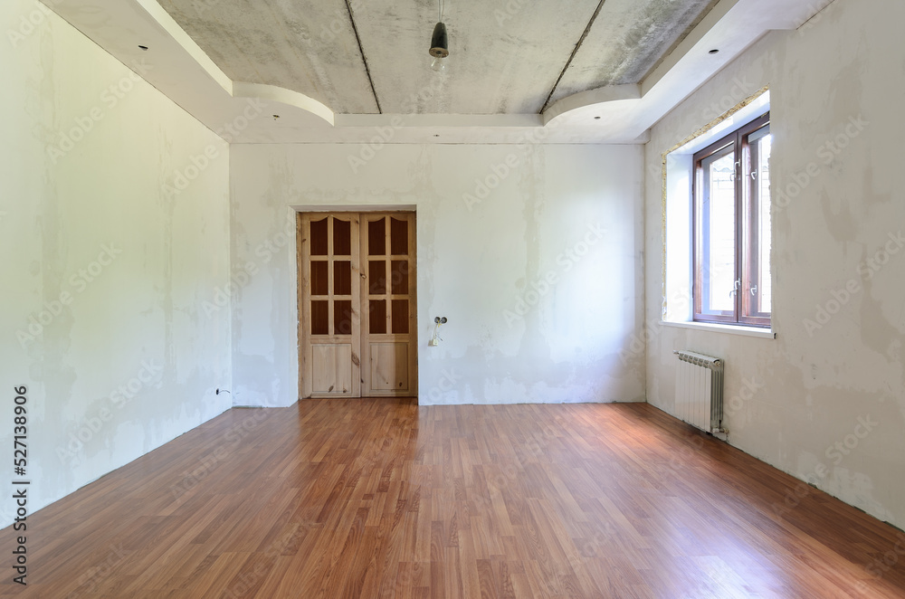 Fototapeta premium The interior of an empty room with a fine renovation, a laminate is laid on the floor