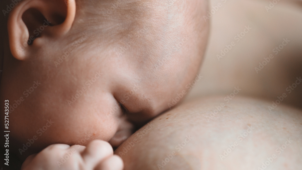 Mother is breast-feeding a newborn baby. Little baby boy breast feeding
