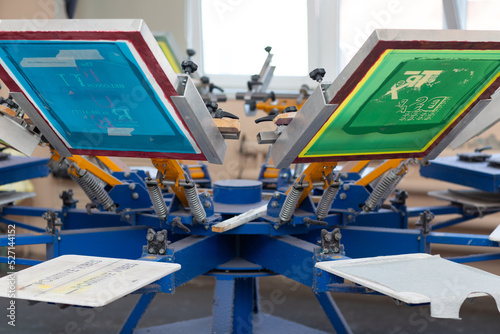 Serigraphy silk screen print process at clothes factory. Frame, squeegee and carousel. photo