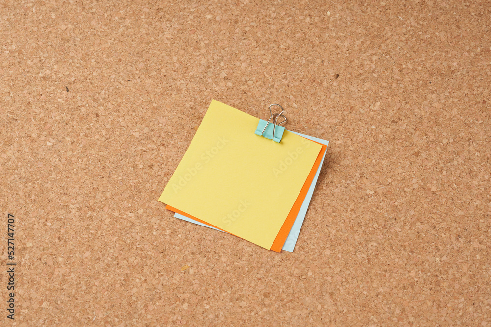 Several multi-colored sheets of paper fastened with a paper clip. Several multi-colored sheets of paper fastened with a paper clip.
