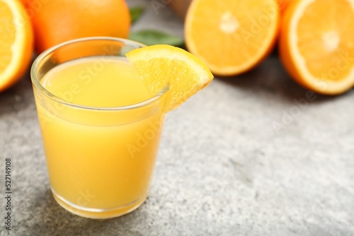 Delicious orange juice and fresh fruit on grey table, closeup. Space for text