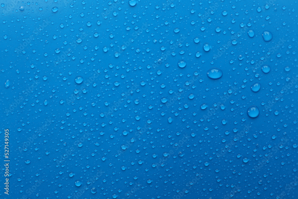 Water drops on light blue background, top view