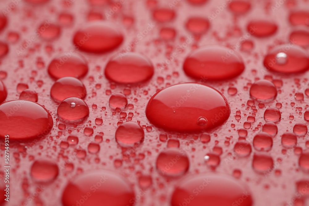 Water drops on red background, closeup view Water drops on red background, closeup view