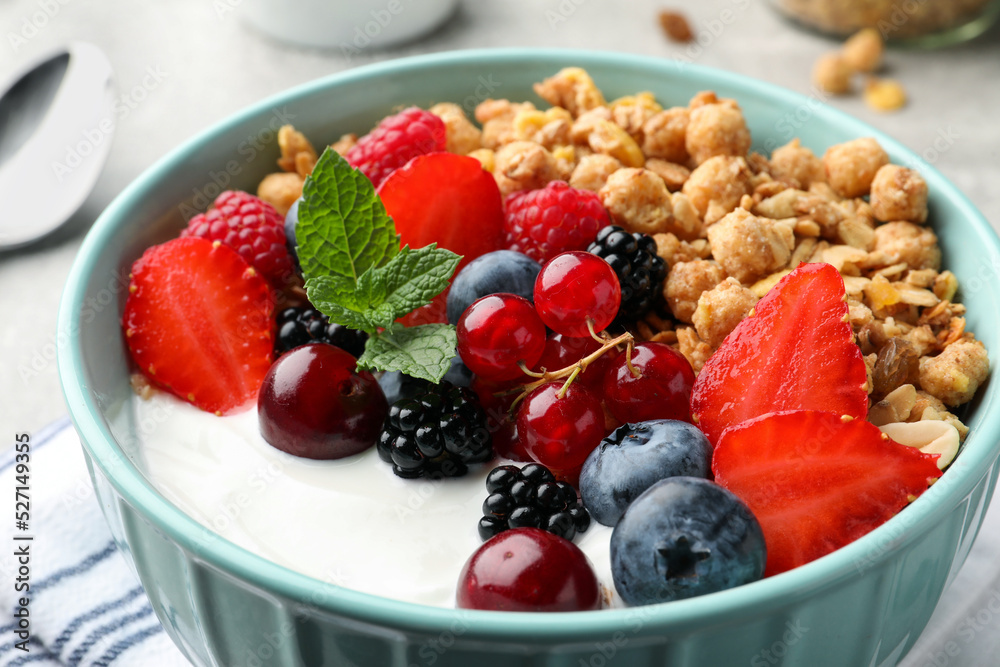 Bowl with tasty granola and berries on table, closeup. Healthy meal