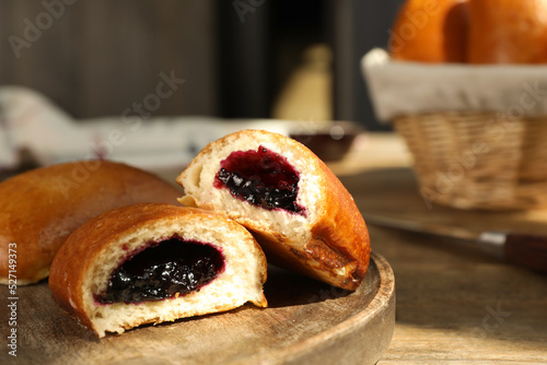 Delicious baked patties with jam on wooden table, closeup photo