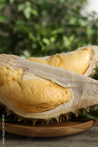 Pieces of fresh ripe durian fruit on wooden table, closeup