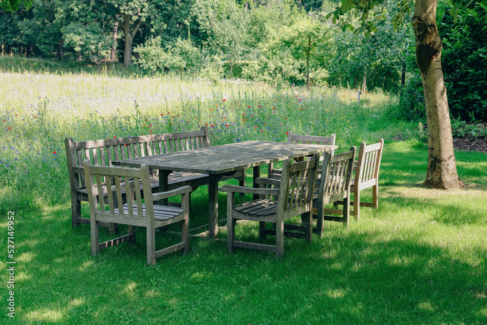 Empty wooden table with bench and chairs on sunny day outdoors