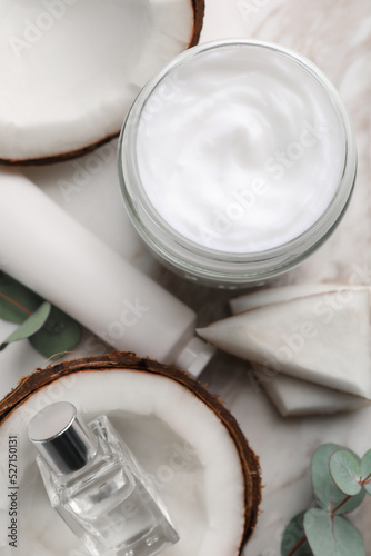 Different hand care cosmetic products  coconut pieces and eucalyptus branch on table  flat lay
