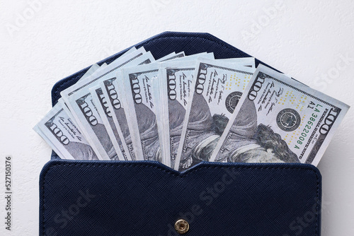 Dollar banknotes in wallet on white table, top view. Money exchange
