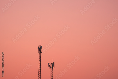 Antenna broadcast signal telecommunication in an pink orange sky background..